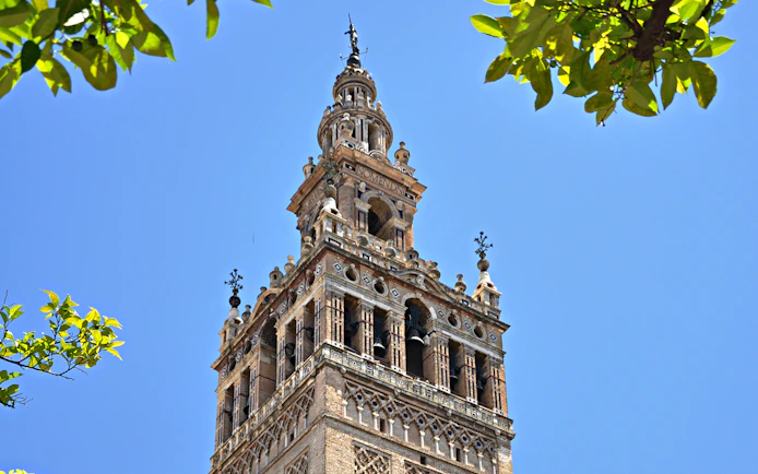 Giralda tower of Seville Cathedral against blue sky, viewed on a day trip from Malaga.