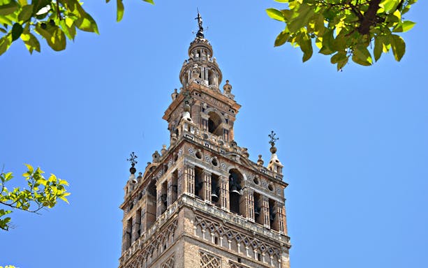 Giralda tower of Seville Cathedral against blue sky, viewed on a day trip from Malaga.