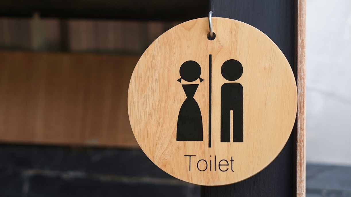 Modern restroom facilities with multiple stalls and sinks in a clean, well-lit environment.