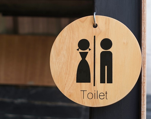 Modern restroom facilities with multiple stalls and sinks in a clean, well-lit environment.