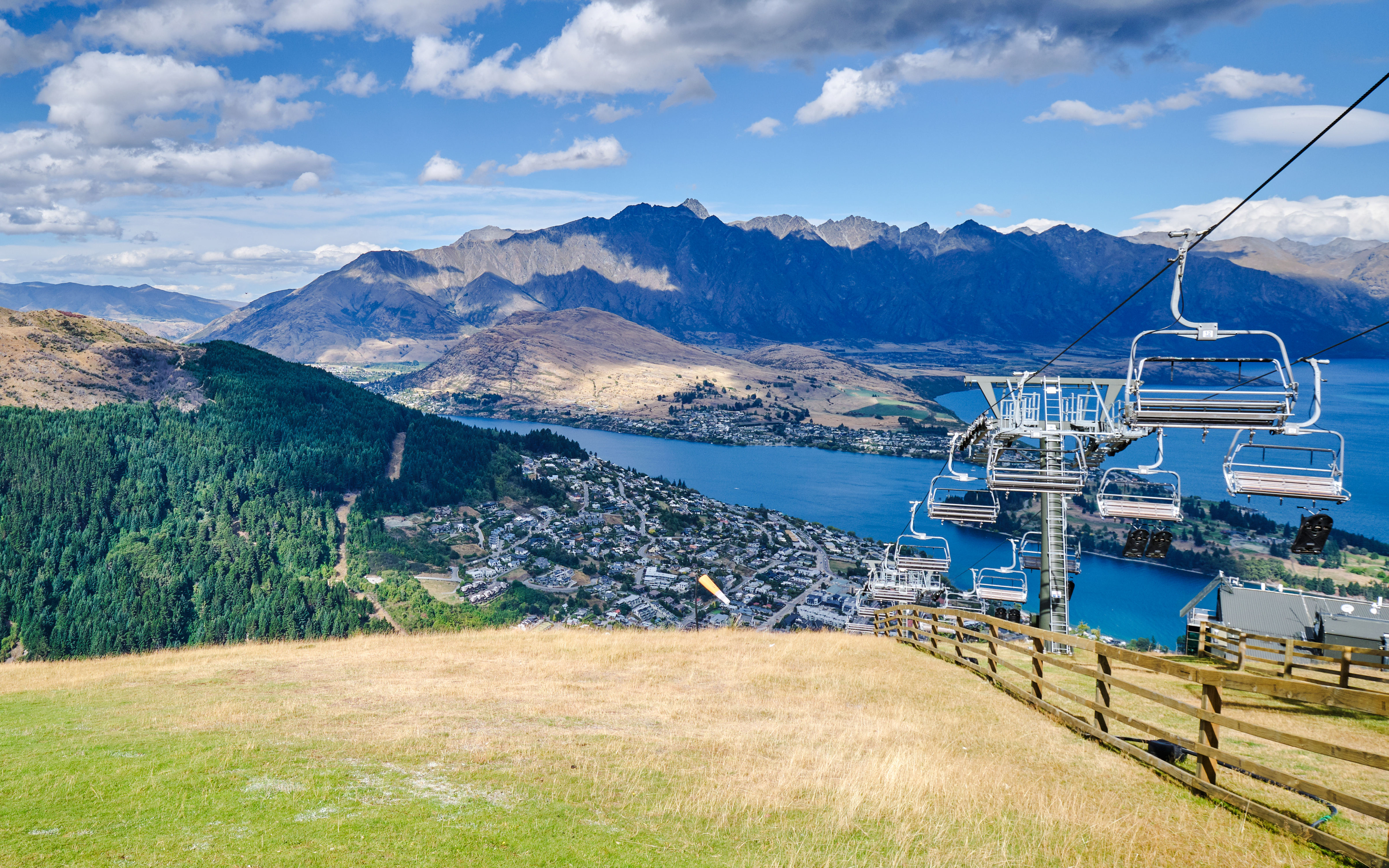 Chairlift ascending Bob's Peak, Queenstown with lake and mountain views.