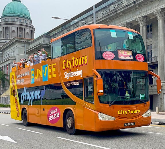 Open-top bus touring Singapore cityscape with iconic skyline views.