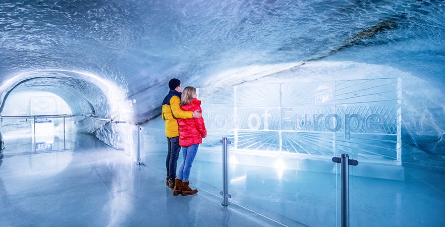 Couple exploring Ice Palace at Jungfraujoch, Switzerland.