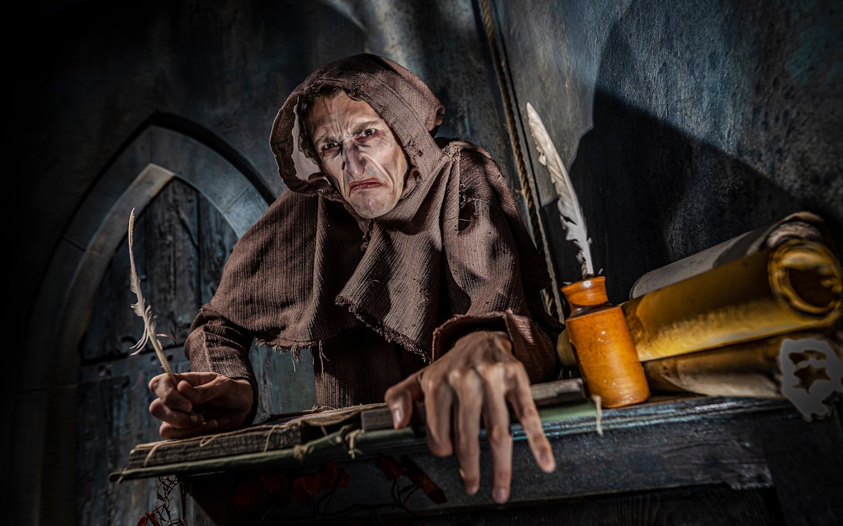 Monk in brown robe with quill at York Dungeon's Vengeance of the Vikings exhibit.