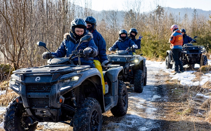 Guests riding quad bikes on a snowy trail in Zakopane.