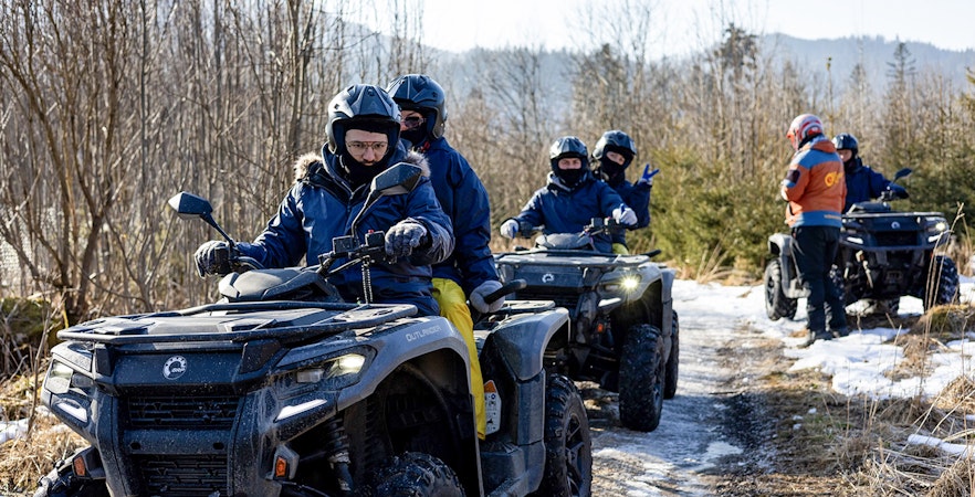 Guests riding quad bikes on a snowy trail in Zakopane.