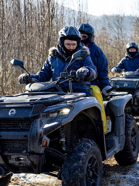 Guests riding quad bikes on a snowy trail in Zakopane.