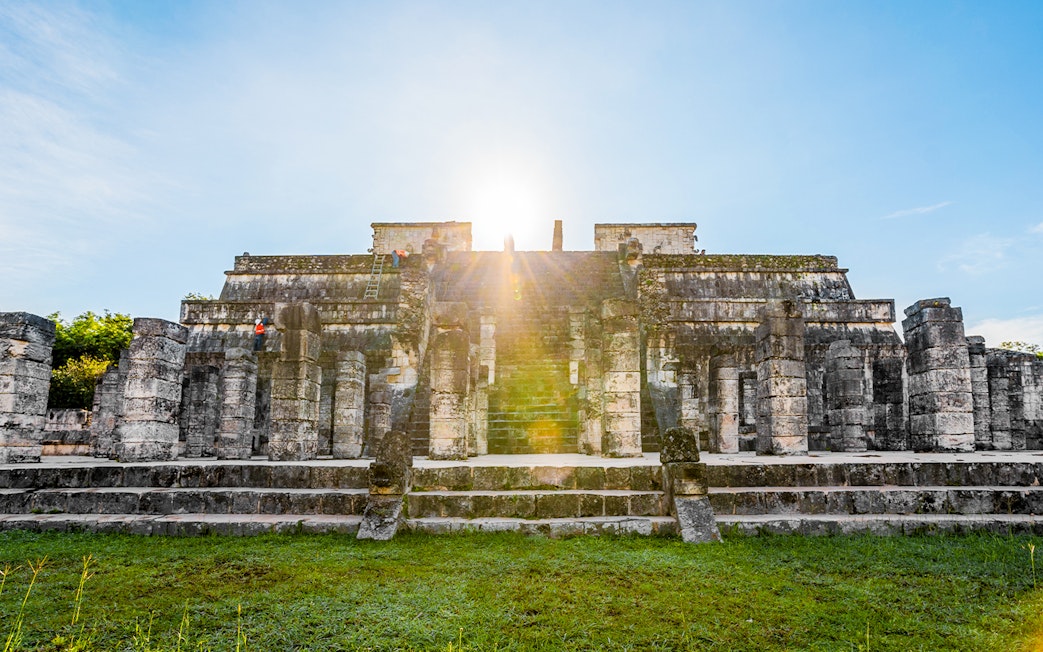 Chichén Itzá temple with sunrise in the background during a guided tour.
