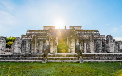 Chichén Itzá temple with sunrise in the background during a guided tour.