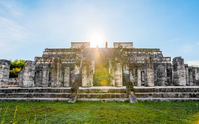 Chichén Itzá temple with sunrise in the background during a guided tour.