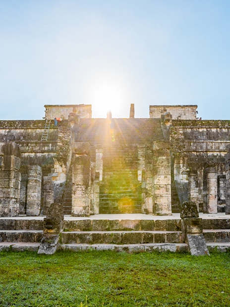 Chichén Itzá temple with sunrise in the background during a guided tour.