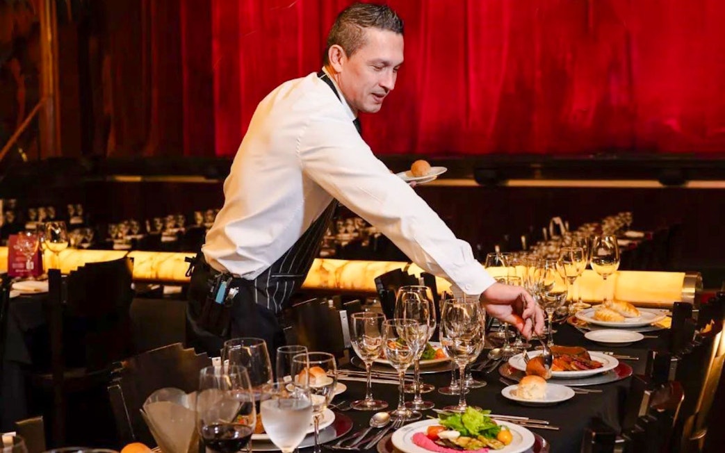 Server setting tables for Tango Porteño Show in Buenos Aires theater.
