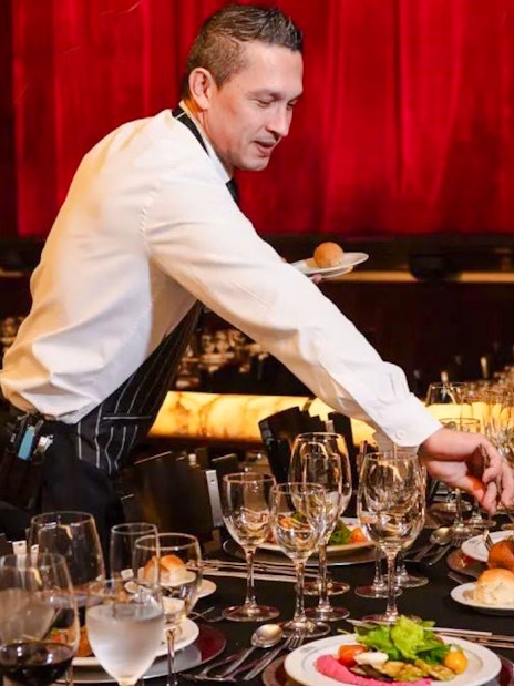 Server setting tables for Tango Porteño Show in Buenos Aires theater.