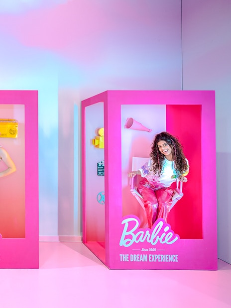 Guests posing inside life-sized Barbie boxes at The Dream Experience.