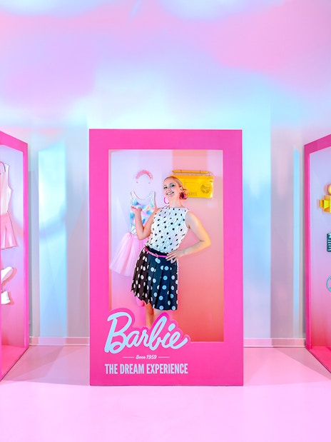 Guests posing inside life-sized Barbie boxes at The Dream Experience.