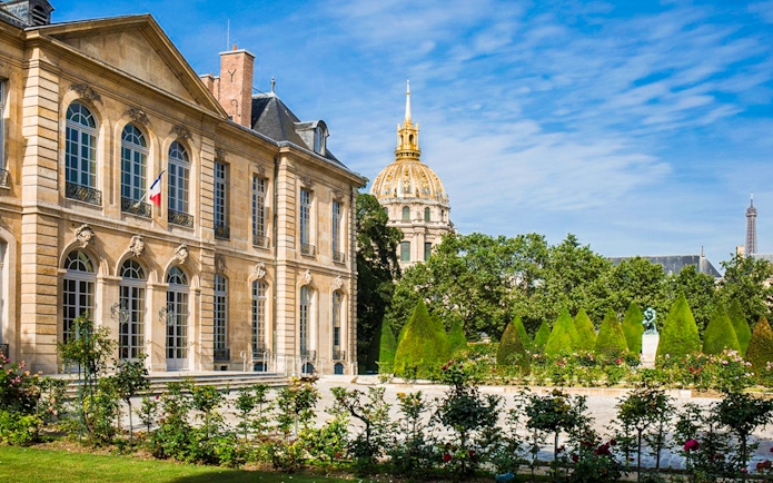 Rodin Museum garden with sculptures and view of Les Invalides dome in Paris.