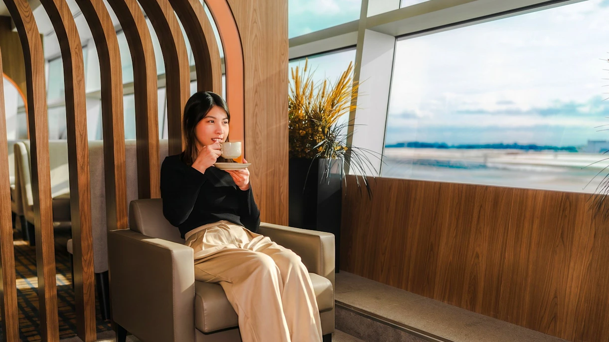 Woman enjoying coffee at Plaza Premium Lounge, Terminal 3, Toronto Pearson Airport.