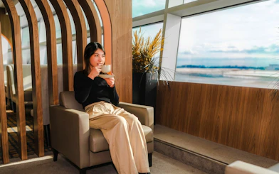 Woman enjoying coffee at Plaza Premium Lounge, Terminal 3, Toronto Pearson Airport.
