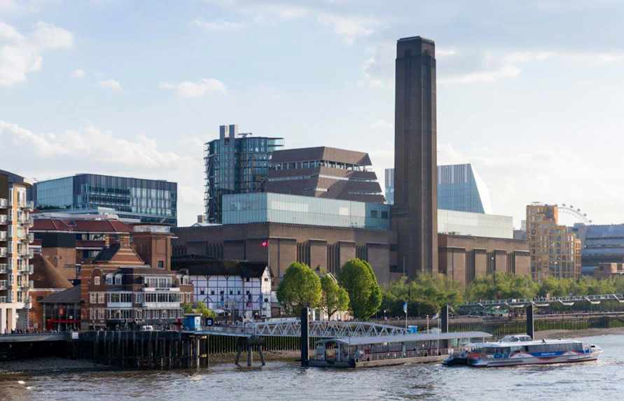 Tate Modern exterior view with river and cityscape in London.