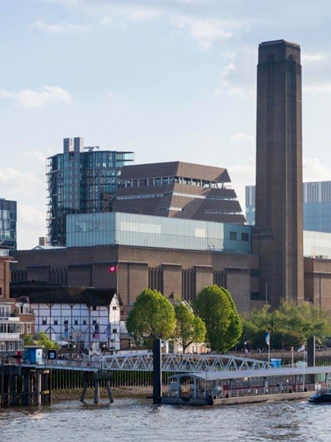 Tate Modern exterior view with river and cityscape in London.
