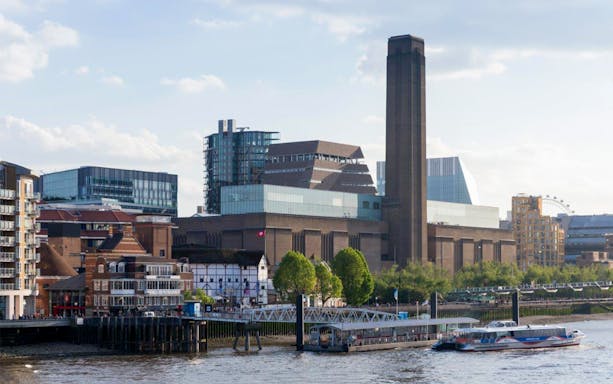 Tate Modern exterior view with river and cityscape in London.