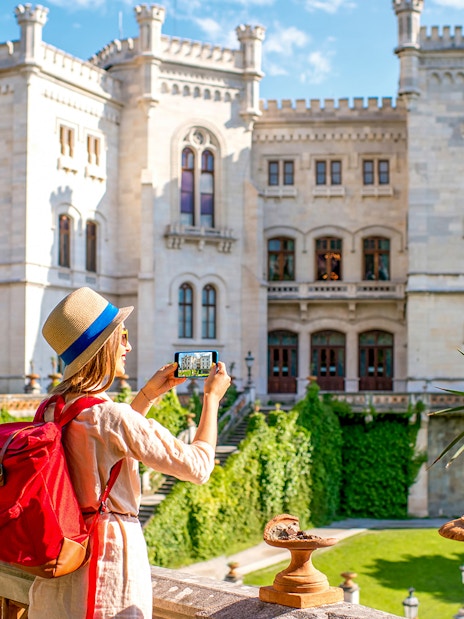Visitor photographing Miramare Castle in Trieste during a private guided tour.