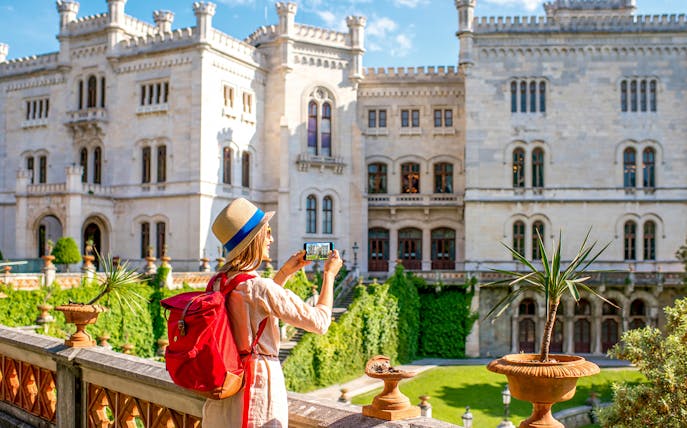Visitor photographing Miramare Castle in Trieste during a private guided tour.
