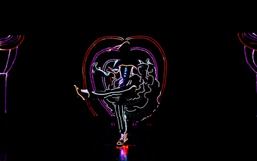 Performer in illuminated costume dancing in iLuminate show.