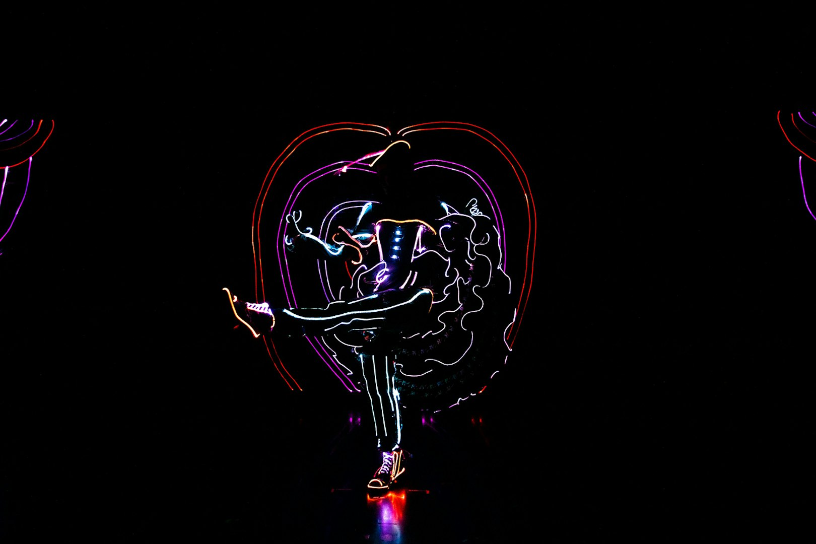 Performer in illuminated costume dancing in iLuminate show.