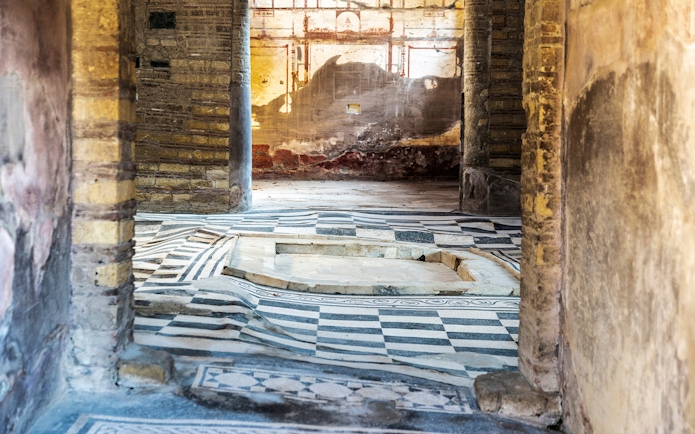 House of the Mosaic Atrium in Herculaneum with intricate floor patterns and ancient walls.