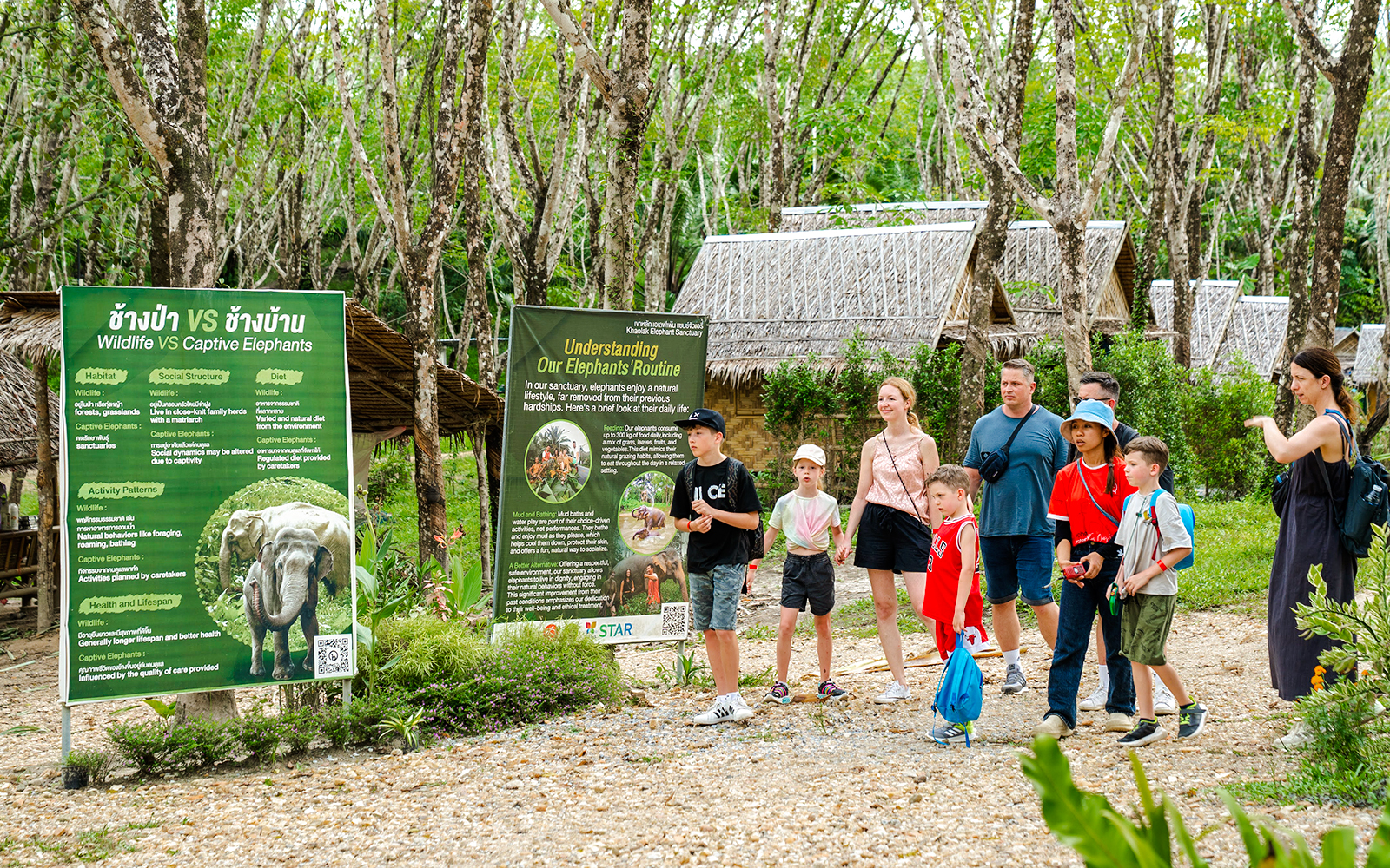 Visitors at Khaolak Ethical Elephant Sanctuary reading educational signs.