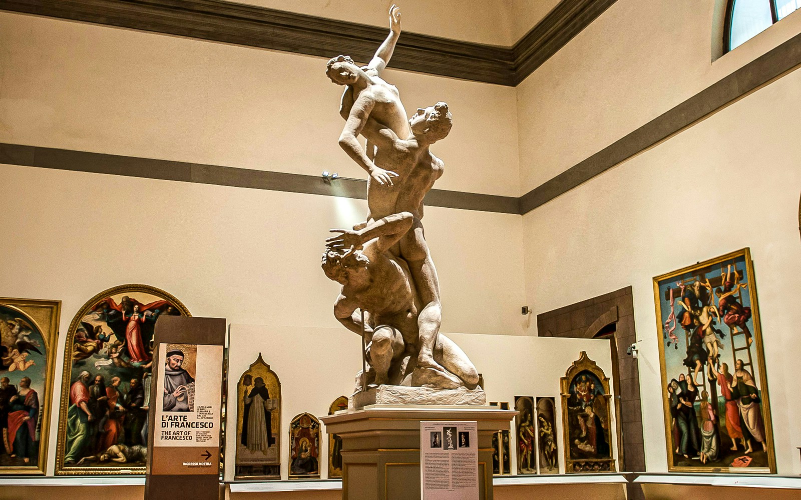 Visitors exploring art at Uffizi & Accademia Galleries, Florence, with audio guide.