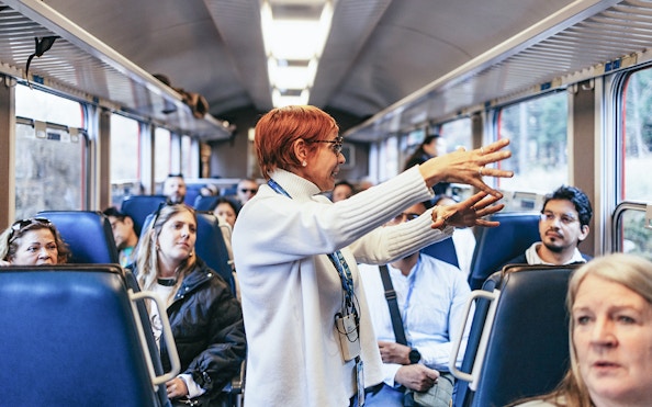 Tour guide speaking to passengers on the Bernina Red Train, St. Moritz.