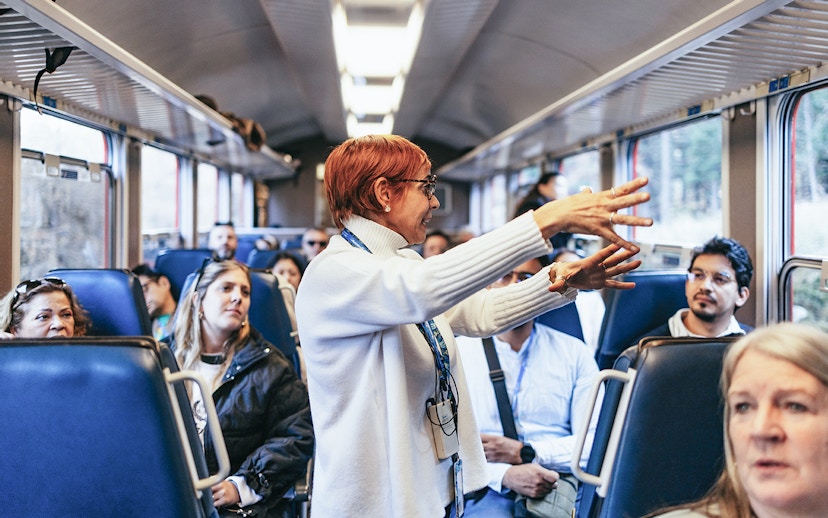 Tour guide speaking to passengers on the Bernina Red Train, St. Moritz.