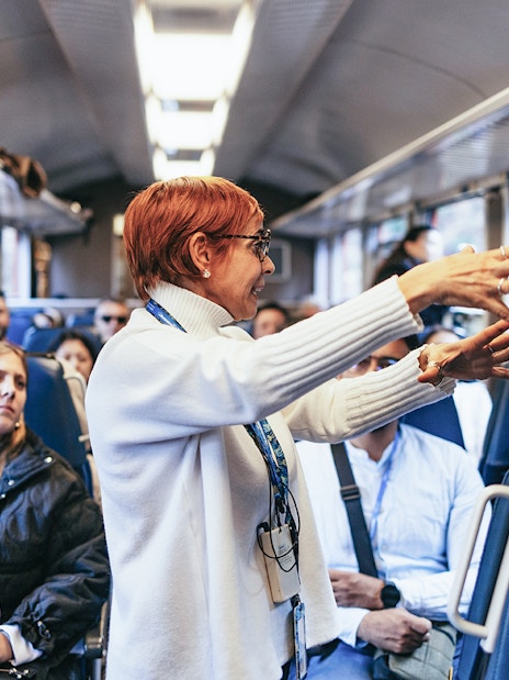 Tour guide speaking to passengers on the Bernina Red Train, St. Moritz.