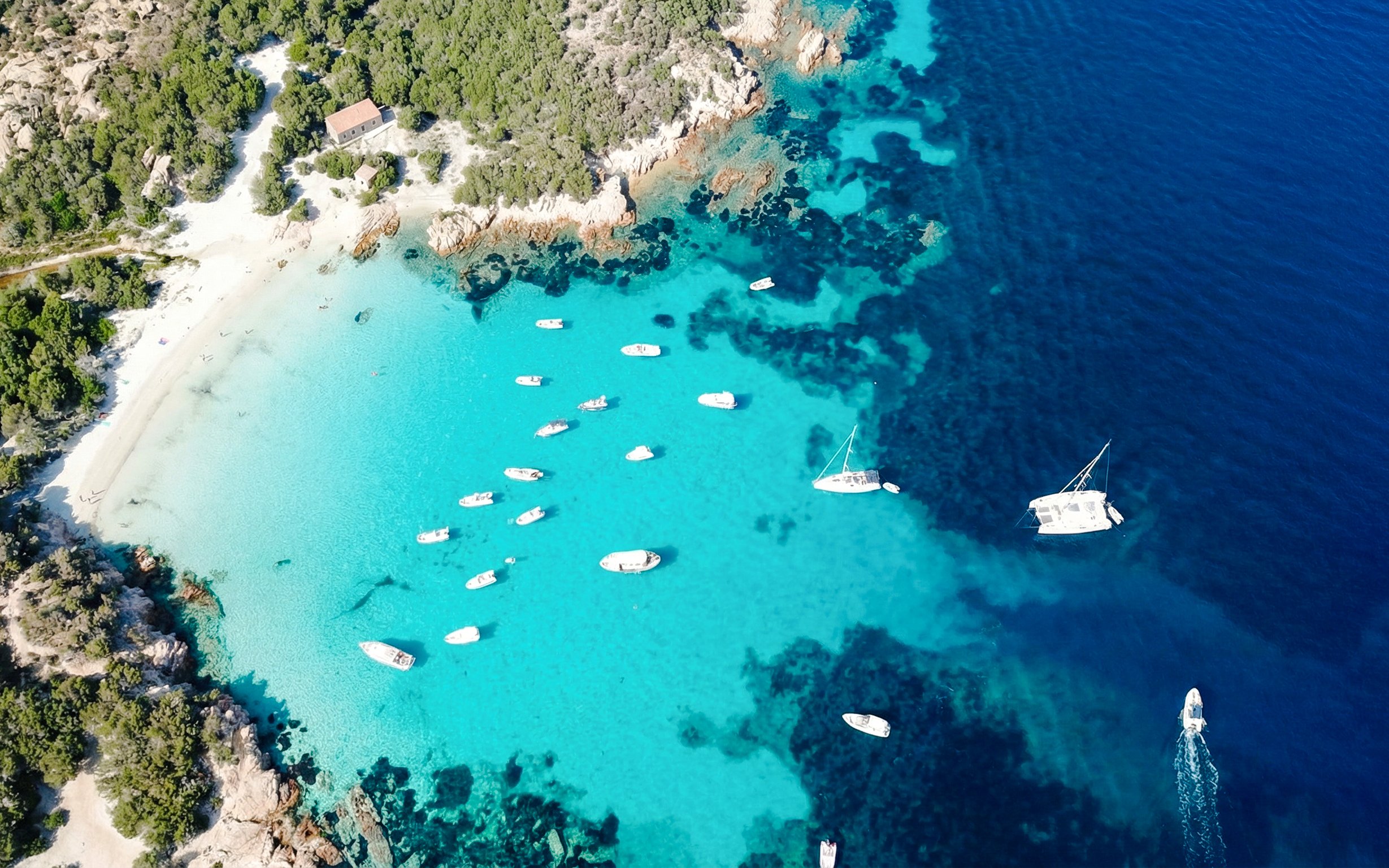 Boats in turquoise waters of La Maddalena Archipelago during a 4-hour RIB tour.