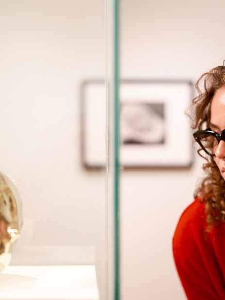Visitors observing a golden sculpture at the H’ART Museum exhibit.