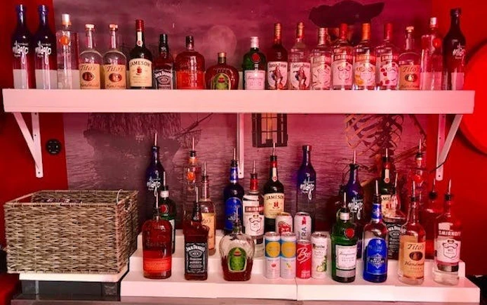 Top shelf open bar with assorted liquor bottles on Boomerang Pirate Ship party cruise.