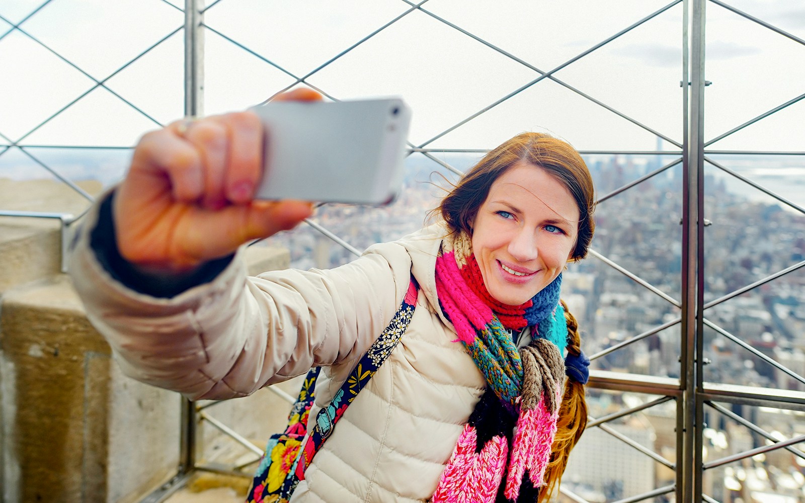 Visitor taking a selfie on the 86th floor of the Empire State Building, New York City.