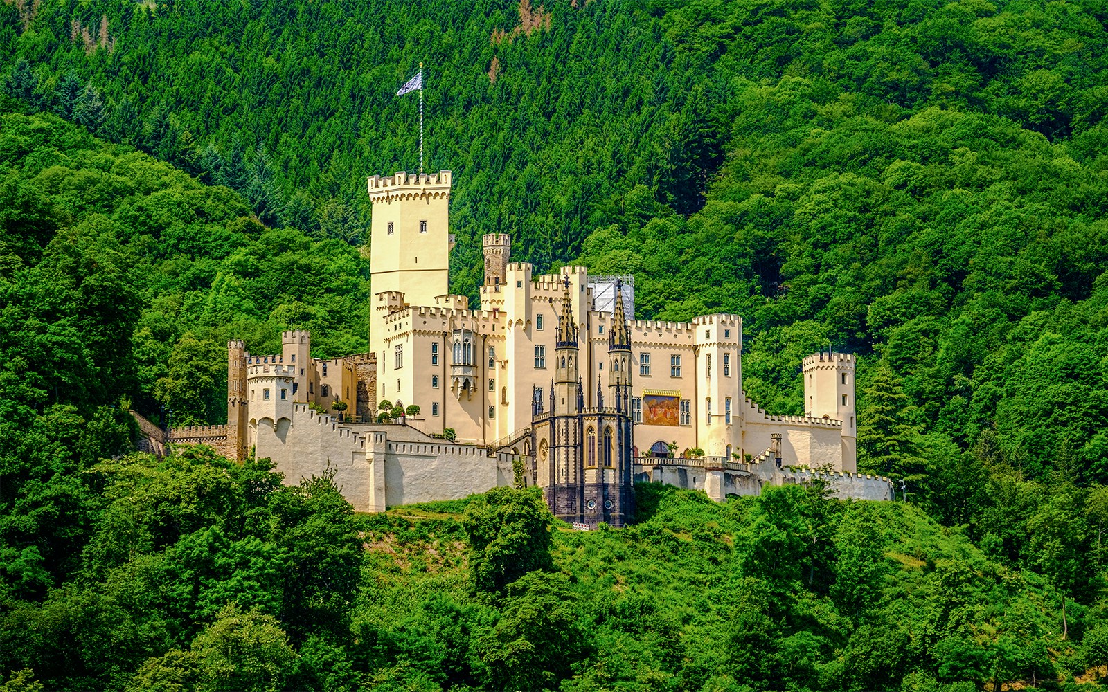 Stolzenfels Castle surrounded by lush greenery, viewed from Koblenz sightseeing cruise.