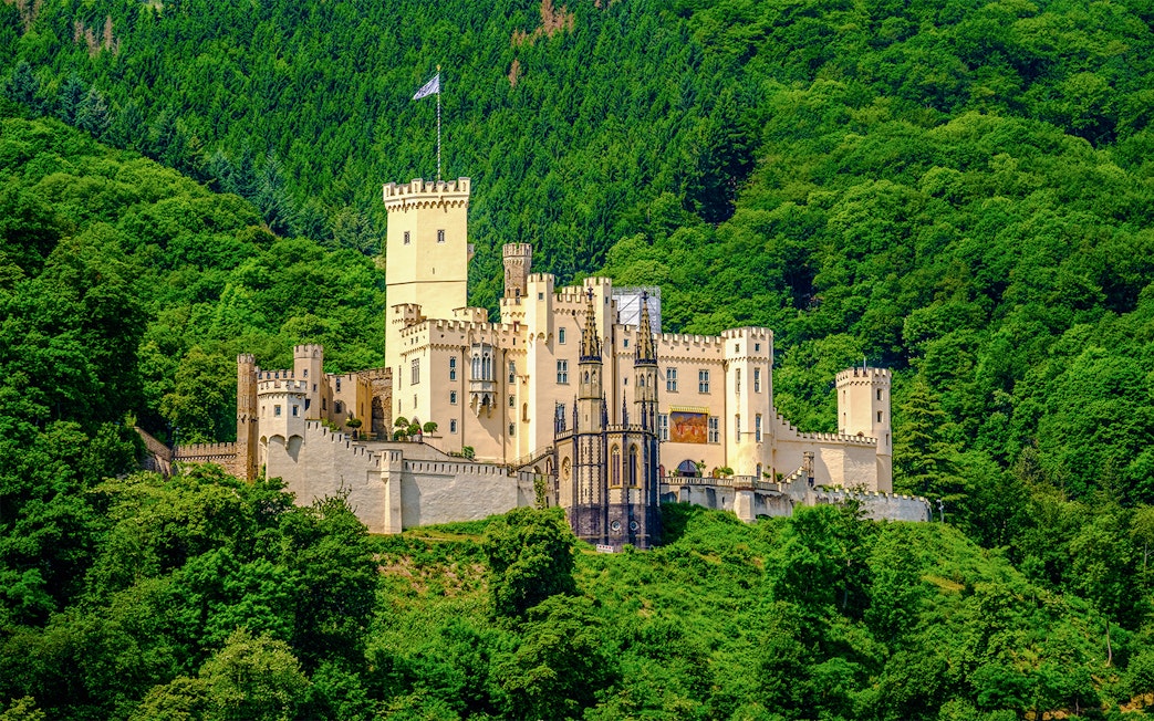Stolzenfels Castle surrounded by lush greenery, viewed from Koblenz sightseeing cruise.