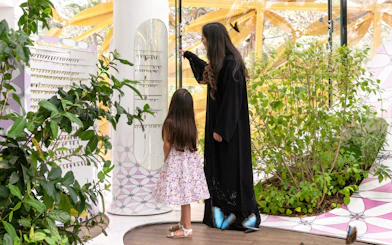Visitors exploring the Butterfly House at Al Noor Island, surrounded by plants and butterflies.