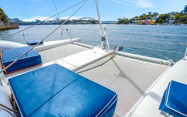 Catamaran deck on Sydney Harbour with view of the bridge in the distance.