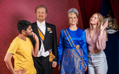 Visitors posing with wax figures at Madame Tussauds Amsterdam.