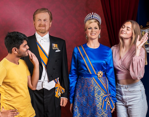 Visitors posing with wax figures at Madame Tussauds Amsterdam.