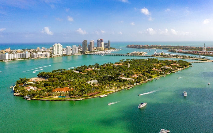 Aerial view of Star Island, Miami, with luxury homes and yachts in Biscayne Bay.