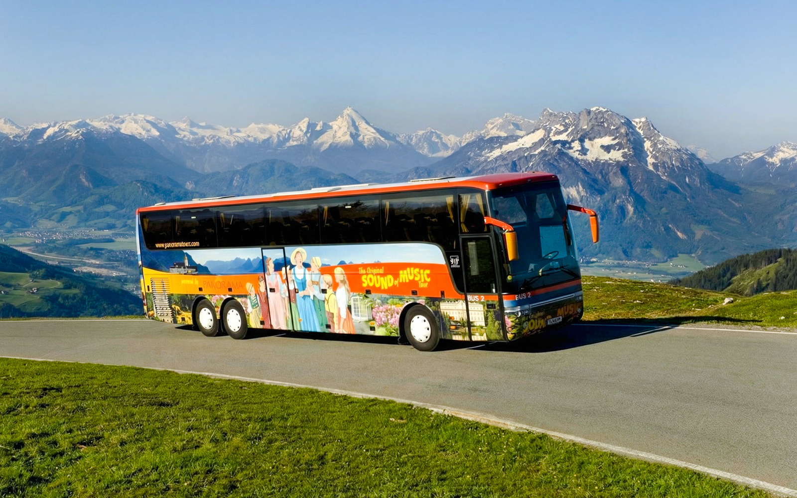 Original Sound of Music tour bus with Alps in the background.