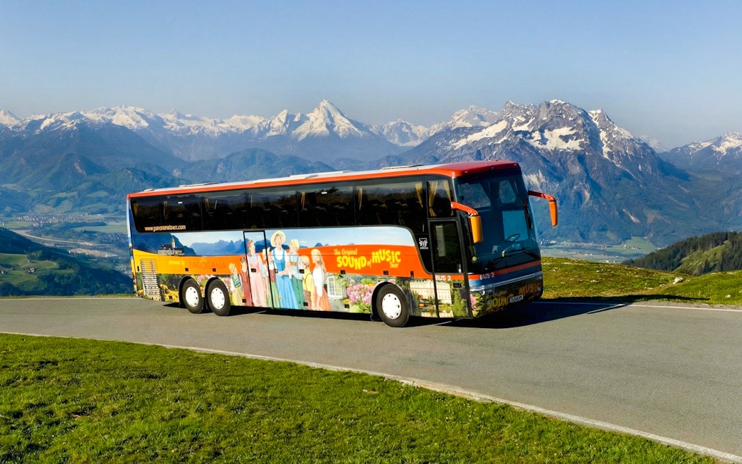Original Sound of Music tour bus with Alps in the background.