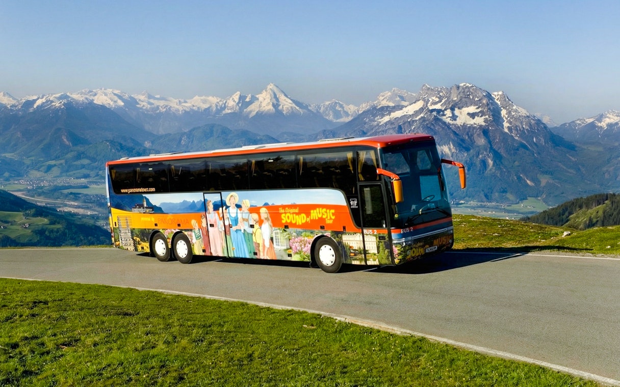 Original Sound of Music tour bus with Alps in the background.