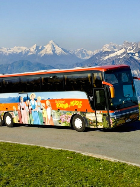 Original Sound of Music tour bus with Alps in the background.